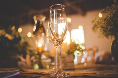 Bu büyüleyici görüntü, gerçek bir düğünün zarif dekorunu ve büyüleyici çiçek düzenlemelerini gözler önüne seriyor. Fotoğrafta zarif çiçekler, mumlar ve diğer dekoratif el ile süslenmiş büyüleyici bir düğün yerinde güzel dekore edilmiş bir masa yer alıyor.