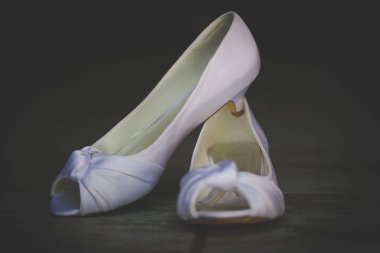 Bu büyüleyici görüntü, küpe, ayakkabı, jartiyer, mücevher ve parfüm gibi gelin aksesuarlarının yaratıcı ve sanatsal bir fotoğrafını sergiliyor. Fotoğraf çeşitli elementlerin güzel bir bileşimidir, karmaşık ayrıntıları vurgular. 