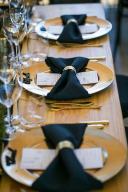 Bu büyüleyici görüntü, gerçek bir düğünün zarif dekorunu ve büyüleyici çiçek düzenlemelerini gözler önüne seriyor. Fotoğrafta zarif çiçekler, mumlar ve diğer dekoratif el ile süslenmiş büyüleyici bir düğün yerinde güzel dekore edilmiş bir masa yer alıyor.