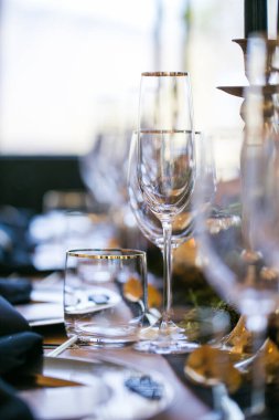 Bu büyüleyici görüntü, gerçek bir düğünün zarif dekorunu ve büyüleyici çiçek düzenlemelerini gözler önüne seriyor. Fotoğrafta zarif çiçekler, mumlar ve diğer dekoratif el ile süslenmiş büyüleyici bir düğün yerinde güzel dekore edilmiş bir masa yer alıyor.