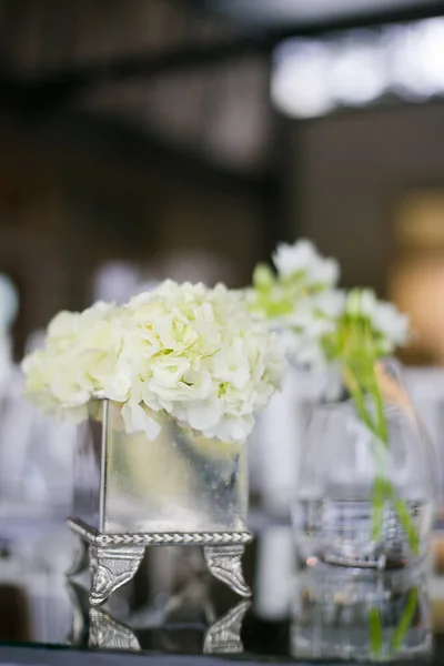 stock image This captivating image showcases the elegant decor and stunning floral arrangements of a real wedding. The photograph features a beautifully decorated table in a charming wedding venue, adorned with delicate flowers, candles, and other decorative ele
