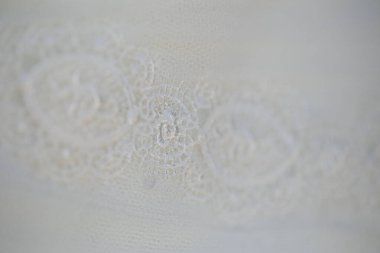 Bu büyüleyici görüntü, yaratıcı ve benzersiz bir şekilde fotoğraflanmış karmaşık detaylarla dolu bir gelinlik sergiliyor. Fotoğrafta karmaşık dantelli ve narin boncuklu çarpıcı beyaz bir gelinlik yer alıyor. Elbisenin fro fotografı var.