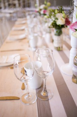 Bu büyüleyici görüntü, gerçek bir düğünün zarif dekorunu ve büyüleyici çiçek düzenlemelerini gözler önüne seriyor. Fotoğrafta zarif çiçekler, mumlar ve diğer dekoratif el ile süslenmiş büyüleyici bir düğün yerinde güzel dekore edilmiş bir masa yer alıyor.