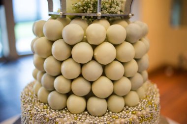 Bu resim, katmanlı keklerden fincan keklere kadar çeşitli çarpıcı düğün pastaları sergiliyor. Fotoğrafta, her biri karmaşık detaylar ve hassas kremalarla özenle dekore edilmiş bir dizi lezzetli pasta yer alıyor. Pastalar vari şeklinde geliyor.