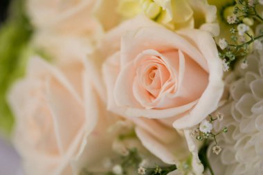 Bu büyüleyici görüntü, gerçek bir düğünün zarif dekorunu ve büyüleyici çiçek düzenlemelerini gözler önüne seriyor. Fotoğrafta zarif çiçekler, mumlar ve diğer dekoratif el ile süslenmiş büyüleyici bir düğün yerinde güzel dekore edilmiş bir masa yer alıyor.