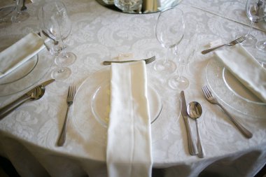 Bu büyüleyici görüntü, gerçek bir düğünün zarif dekorunu ve büyüleyici çiçek düzenlemelerini gözler önüne seriyor. Fotoğrafta zarif çiçekler, mumlar ve diğer dekoratif el ile süslenmiş büyüleyici bir düğün yerinde güzel dekore edilmiş bir masa yer alıyor.