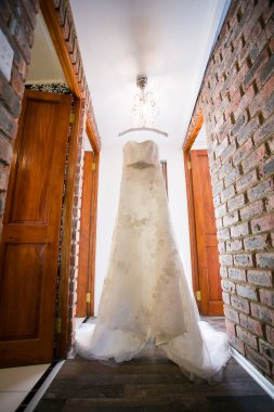 Bu büyüleyici görüntü, yaratıcı ve benzersiz bir şekilde fotoğraflanmış karmaşık detaylarla dolu bir gelinlik sergiliyor. Fotoğrafta karmaşık dantelli ve narin boncuklu çarpıcı beyaz bir gelinlik yer alıyor. Elbisenin fro fotografı var.