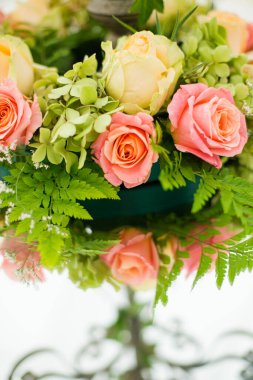 Bu büyüleyici görüntü, gerçek bir düğünün zarif dekorunu ve büyüleyici çiçek düzenlemelerini gözler önüne seriyor. Fotoğrafta zarif çiçekler, mumlar ve diğer dekoratif el ile süslenmiş büyüleyici bir düğün yerinde güzel dekore edilmiş bir masa yer alıyor.