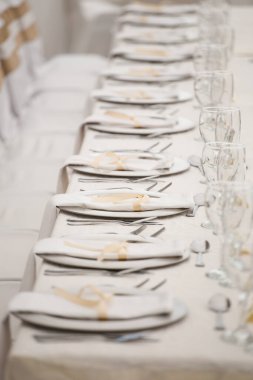 Bu büyüleyici görüntü, gerçek bir düğünün zarif dekorunu ve büyüleyici çiçek düzenlemelerini gözler önüne seriyor. Fotoğrafta zarif çiçekler, mumlar ve diğer dekoratif el ile süslenmiş büyüleyici bir düğün yerinde güzel dekore edilmiş bir masa yer alıyor.