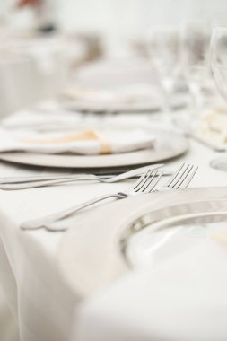 Bu büyüleyici görüntü, gerçek bir düğünün zarif dekorunu ve büyüleyici çiçek düzenlemelerini gözler önüne seriyor. Fotoğrafta zarif çiçekler, mumlar ve diğer dekoratif el ile süslenmiş büyüleyici bir düğün yerinde güzel dekore edilmiş bir masa yer alıyor.