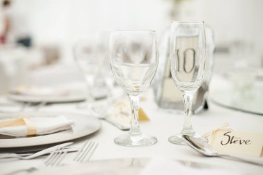 Bu büyüleyici görüntü, gerçek bir düğünün zarif dekorunu ve büyüleyici çiçek düzenlemelerini gözler önüne seriyor. Fotoğrafta zarif çiçekler, mumlar ve diğer dekoratif el ile süslenmiş büyüleyici bir düğün yerinde güzel dekore edilmiş bir masa yer alıyor.