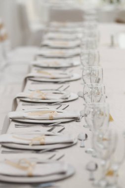 Bu büyüleyici görüntü, gerçek bir düğünün zarif dekorunu ve büyüleyici çiçek düzenlemelerini gözler önüne seriyor. Fotoğrafta zarif çiçekler, mumlar ve diğer dekoratif el ile süslenmiş büyüleyici bir düğün yerinde güzel dekore edilmiş bir masa yer alıyor.