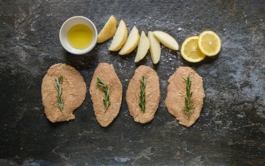 İştah açıcı ve pişmeye hazır görünmesi için seçici tavuk eti kesiklerinin düz bir fotoğrafını serin.