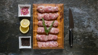 İştah açıcı ve pişmeye hazır görünmesi için seçici tavuk eti kesiklerinin düz bir fotoğrafını serin.