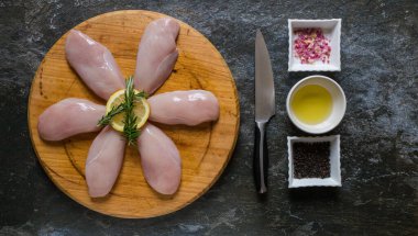 İştah açıcı ve pişmeye hazır görünmesi için seçici tavuk eti kesiklerinin düz bir fotoğrafını serin.