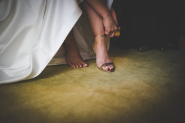 Gelin giyinirken, aile fertlerinin yardım ettiği, ayakkabılarını ve jartiyerini giydiği ve büyük günü beklentisiyle elbisesinin kapandığı dokunaklı bir an..