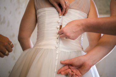 Gelin giyinirken, aile fertlerinin yardım ettiği, ayakkabılarını ve jartiyerini giydiği ve büyük günü beklentisiyle elbisesinin kapandığı dokunaklı bir an..