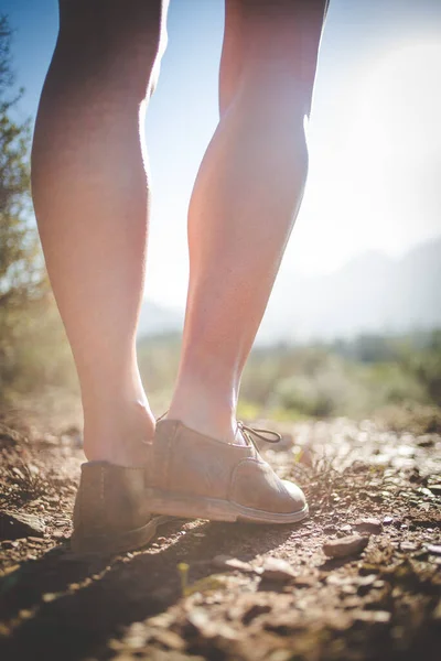 stock image Close up image of a pretty woman with muscular legs walking on a dirt road wearing handmade leather shoes.