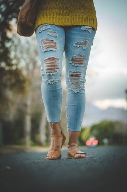 El yapımı deri ayakkabılar giyen kaslı bacaklı güzel bir kadın resmi..