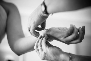 Gelin giyinirken, aile fertlerinin yardım ettiği, ayakkabılarını ve jartiyerini giydiği ve büyük günü beklentisiyle elbisesinin kapandığı dokunaklı bir an..