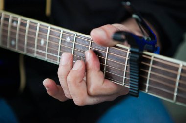 Bir fonksiyonda gitar çalan kişinin elleri ve enstrümanına odaklandığı yakın plan..