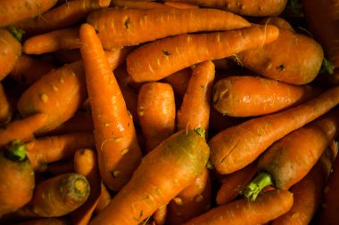 A close-up of freshly harvested carrots with earthy textures, vibrant orange hues, and natural imperfections, ideal for showcasing raw produce or farm-to-table concepts. clipart