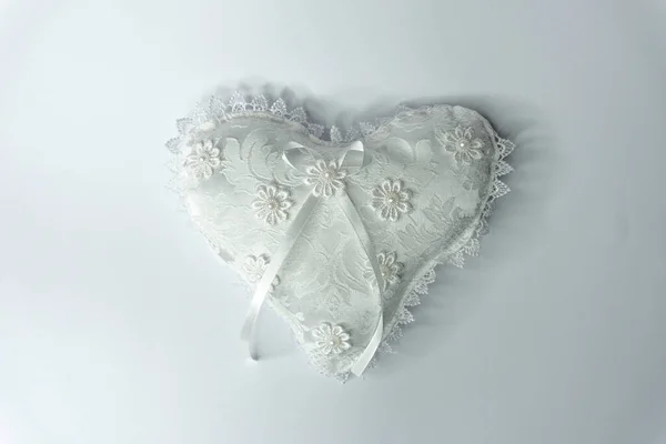 White silk pillow in the shape of heart