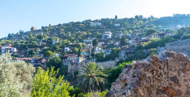 Eski liman duvarları ve Alanya, Türkiye 'deki Tersane Plaji plajı. Arka planda insanlar ve konut binaları var.