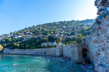 Antalya 'nın Alanya yarımadasındaki Kizil Kule kulesi yakınlarındaki antik tersane manzarası, yüksek dağları olan ünlü turizm beldesi. eski Kale