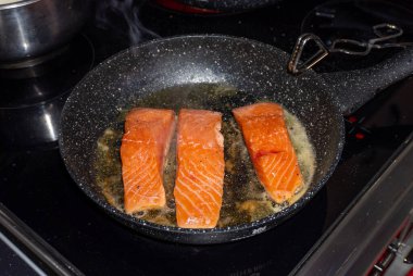 Tavada somon bifteği pişiriyorum.