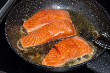 Tavada somon bifteği pişiriyorum.