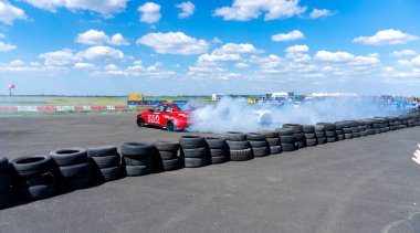 Arad, Arad Romanya - 05 06 2024: BMW arabası asfalt yarış pistinde sürükleniyor çok fazla duman ve hareket bulanıklığı olan RoDrag Etkinliği
