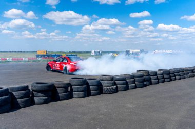Arad, Arad Romanya - 05 06 2024: BMW arabası asfalt yarış pistinde sürükleniyor çok fazla duman ve hareket bulanıklığı olan RoDrag Etkinliği
