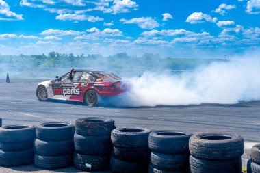 Arad, Arad Romanya - 05 06 2024: BMW arabası asfalt yarış pistinde sürükleniyor çok fazla duman ve hareket bulanıklığı olan RoDrag Etkinliği