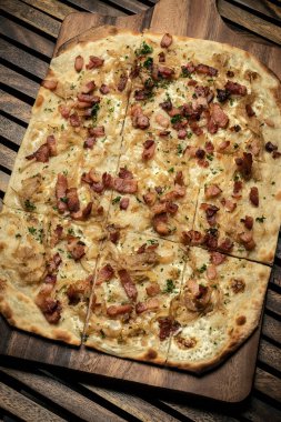 Flammkuchen tarte flambee rectangular pizza with bacon and chicken on wood table background