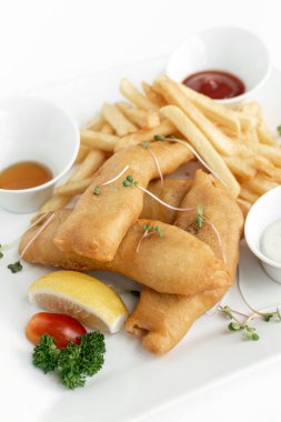 İngiliz geleneksel balık ve patates kızartması restoranda beyaz tabakta ve beyaz arka planda
