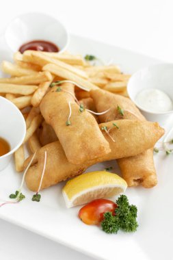 İngiliz geleneksel balık ve patates kızartması restoranda beyaz tabakta ve beyaz arka planda
