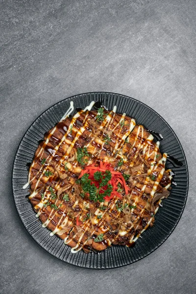 Meşhur Okonomiyaki geleneksel Japon baharatlı krepi restoranında gri arka planda.