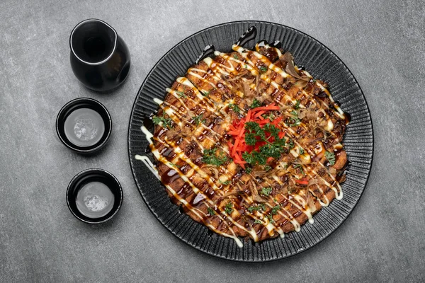 Berühmte Okonomiyaki Traditionelles Japanisches Herzhaftes Pfannkuchengericht Restaurant Auf Grauem Hintergrund lizenzfreie Stockbilder