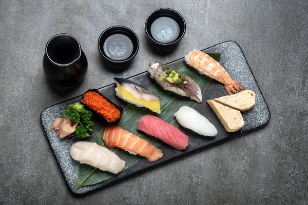 Omakas Blandad Sushi Set Med Sake Grå Bakgrund Japansk Restaurang Stockfoto