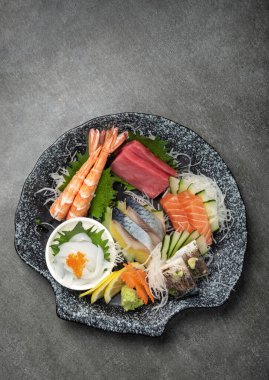 Japon restoranında gri arka planda karışık sashimi suşi tabağı.