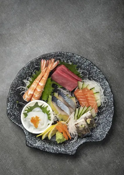 灰色背景的日本餐馆里的混合寿司盘 免版税图库图片