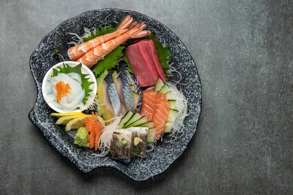 灰色背景的日本餐馆里的混合寿司盘 免版税图库照片
