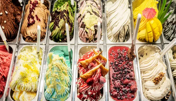 Bir dükkan vitrininde renkli zanaat dondurması çeşitleri.