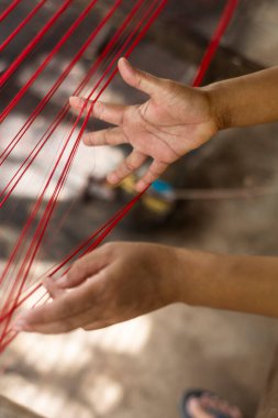Geleneksel doğal ipek üretim makinesi telleriyle işçi elleri detayı