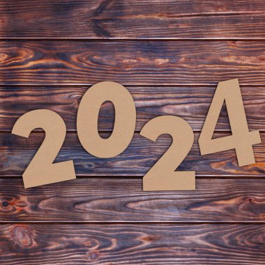 Cardstock Numarası 2024 Mutlu Yıllar tabelası ahşap masa arkasında. 3d Hazırlama