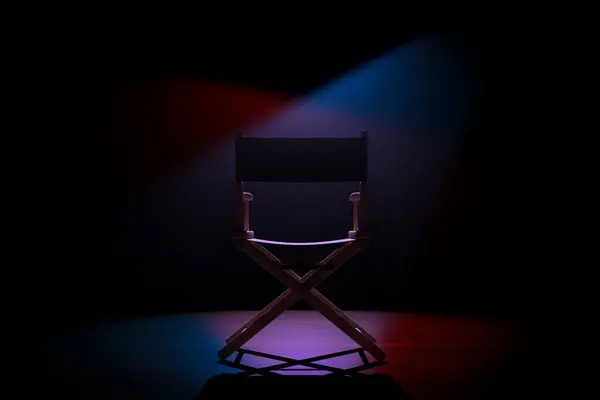 Cinema Industry Concept. Back of Director Chair in Spotlight Lights on a black background. 3d Rendering