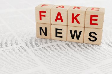 Yanlış bilgi kavramı. Tahta bloklar ve sahte mesajlar gazetenin arka planına yerleştirildi. Son derece yakın çekim. 3d Hazırlama