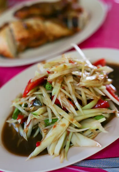 Thai food (Som Tum), Spicy green papaya salad eating with grilled chicken wing and sticky rice