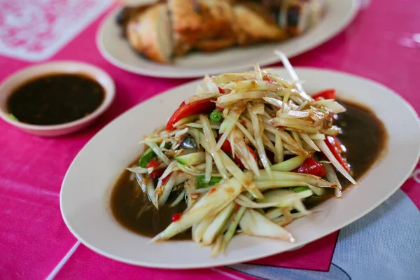 Thai food (Som Tum), Spicy green papaya salad eating with grilled chicken wing and sticky rice